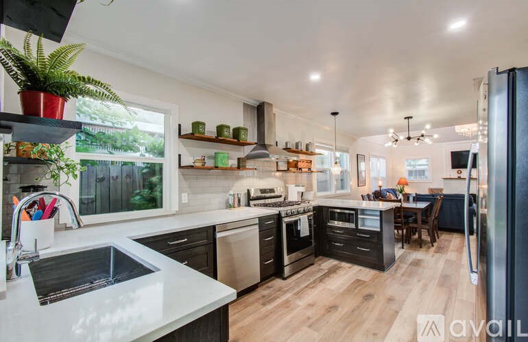 A kitchen with a sink, stove, and refrigerator.