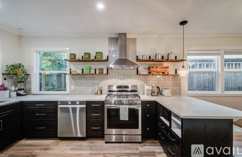 A kitchen with black cabinets and stainless steel appliances.