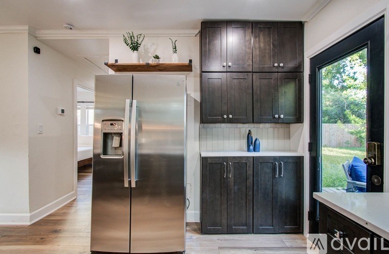 A modern kitchen with dark wood cabinets and a stainless steel refrigerator.