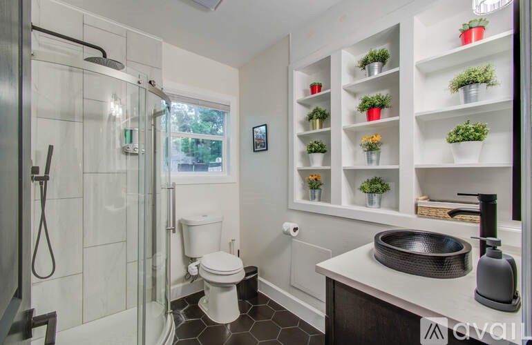 A bathroom with a toilet, sink, and a shower with a glass door.