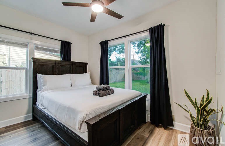 A bedroom with a large bed and a ceiling fan.