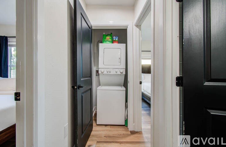 A white washing machine is in a narrow hallway.