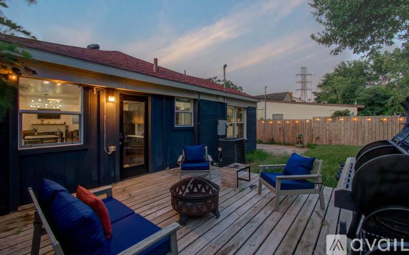 A deck with a blue couch and a table with a vase on it.