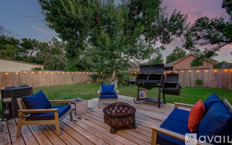 A wooden deck with a grill and chairs.