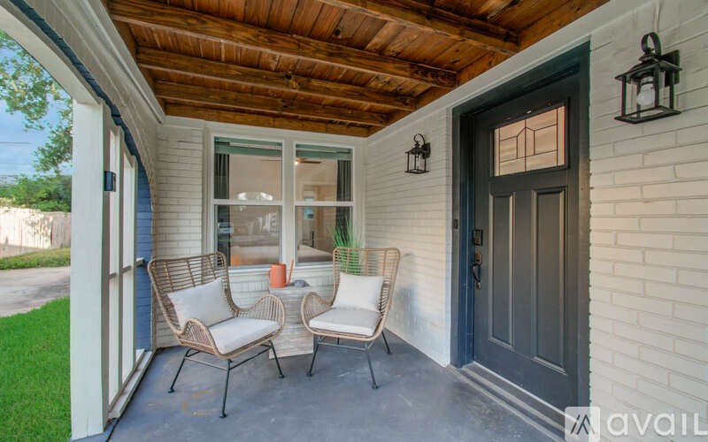 A porch with two chairs and a table.