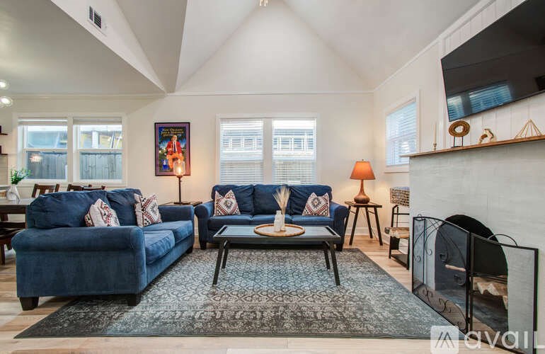 A living room with a blue couch and a fireplace.