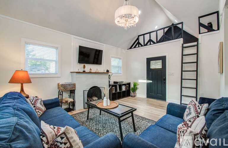 A living room with a blue couch and a fireplace.