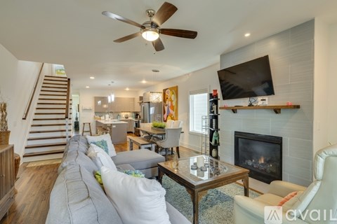 A living room with a fireplace and a television on the wall.