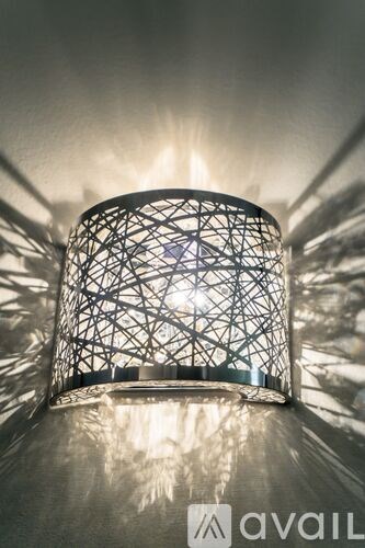 A lamp with a geometric pattern is casting a bright light.