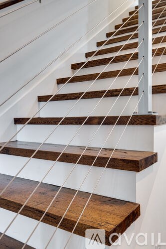 A set of stairs with wooden steps and white railings.