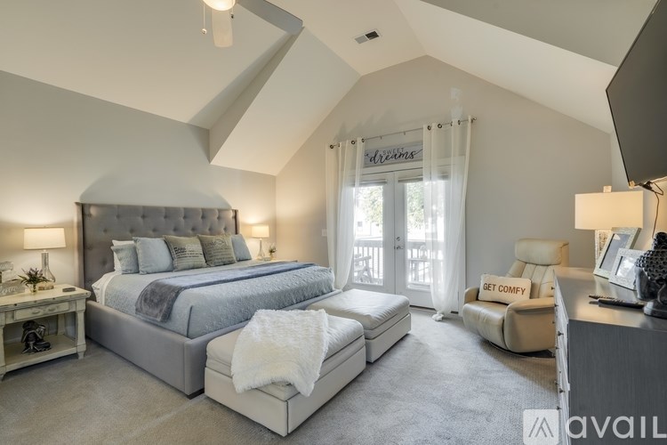 A bedroom with a large bed and a chair is available for rent.