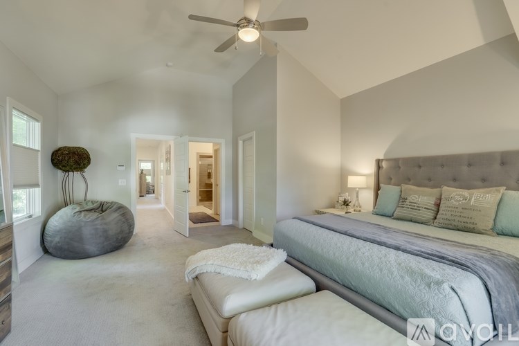 A bedroom with a large bed and a ceiling fan.