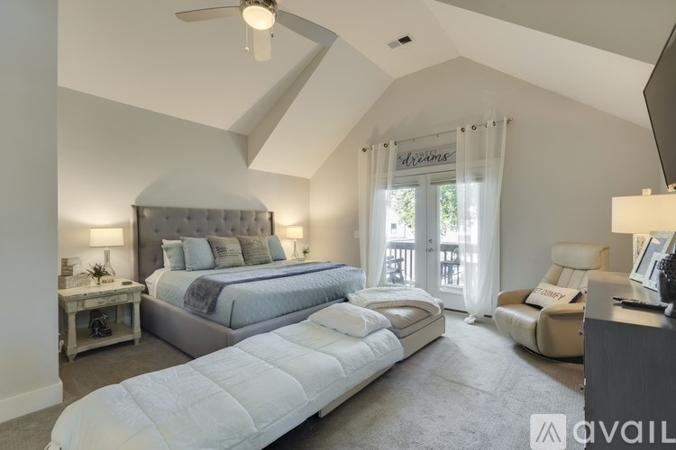 A bedroom with a large bed and a chair.