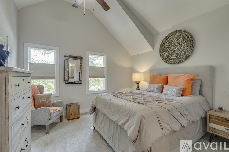 A bedroom with a large bed and a ceiling fan.