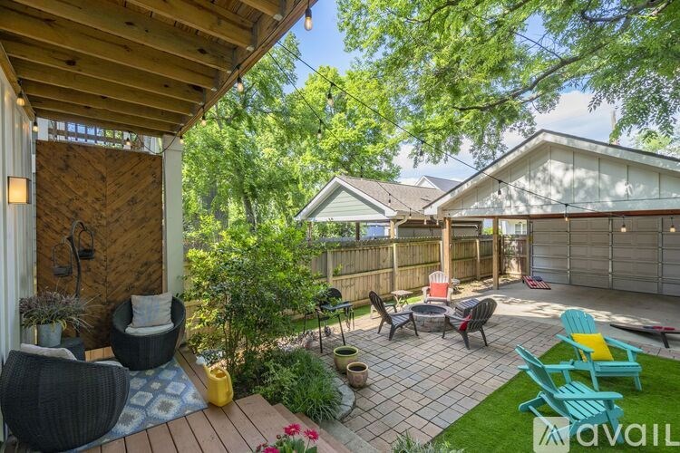 A backyard with a wooden deck and patio furniture.