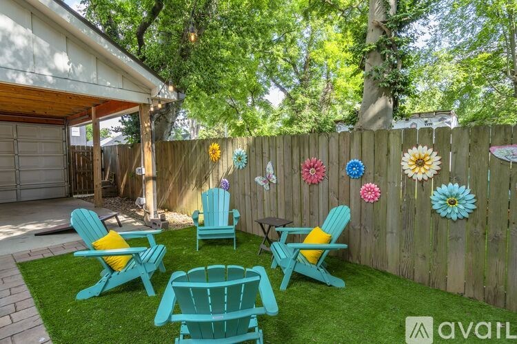 A backyard with a table, chairs, and a fence.