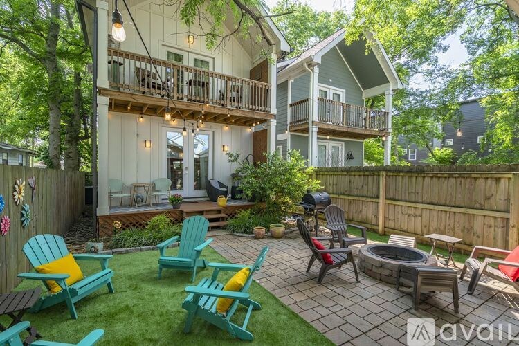 A patio with a fire pit and chairs.