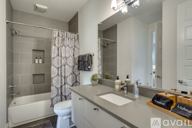 A bathroom with a white tub, sink, and toilet.