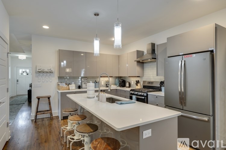 A kitchen with a white counter top and stainless steel appliances.
