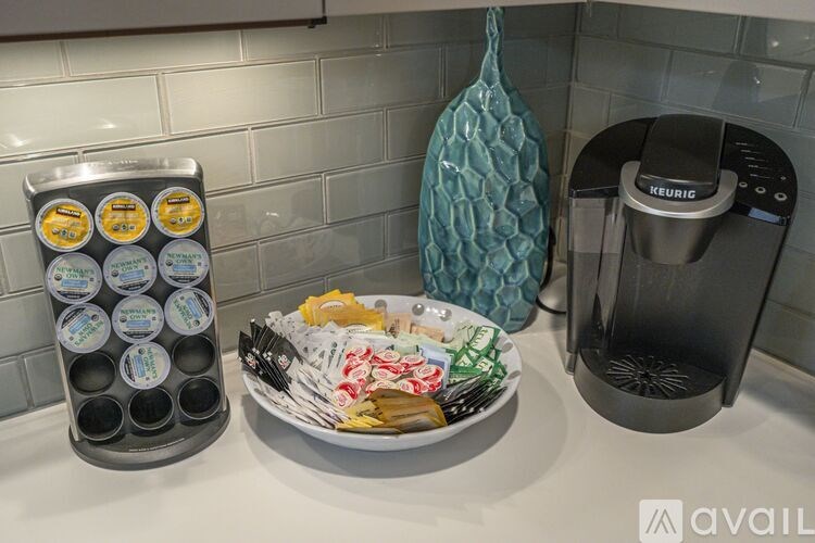 A kitchen counter with a plate of food, a container of ice cream, and a Keurig coffee maker.