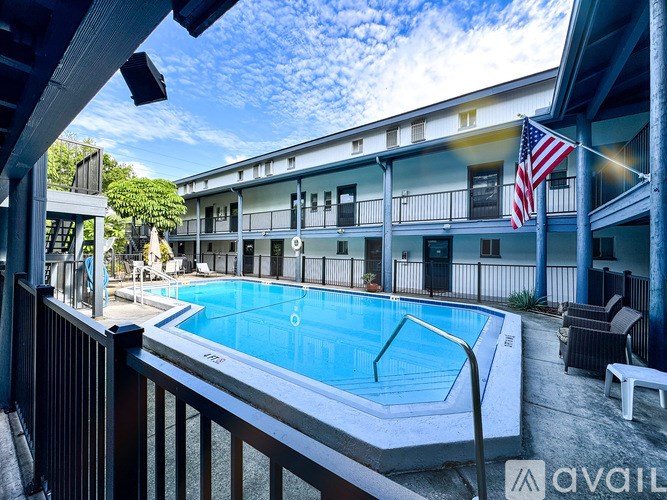 A pool in a backyard with a building in the background.