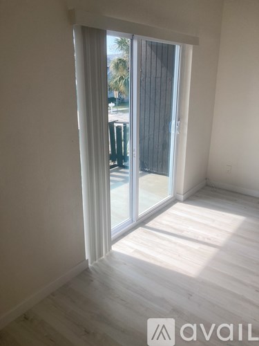 A room with a sliding glass door leading to a balcony.