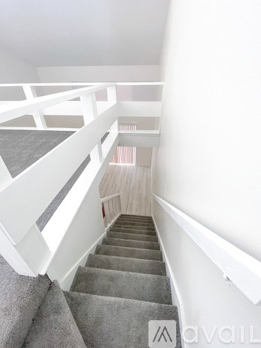 A staircase with a carpeted runner and white railings.