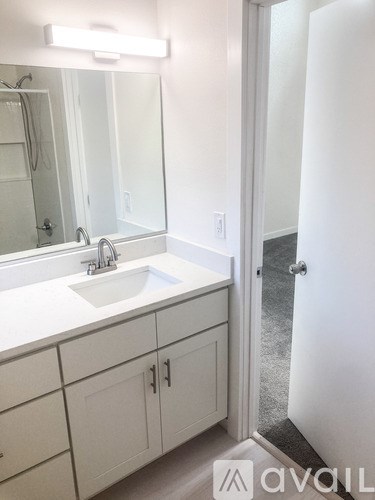 A bathroom with a sink, mirror, and cabinets.