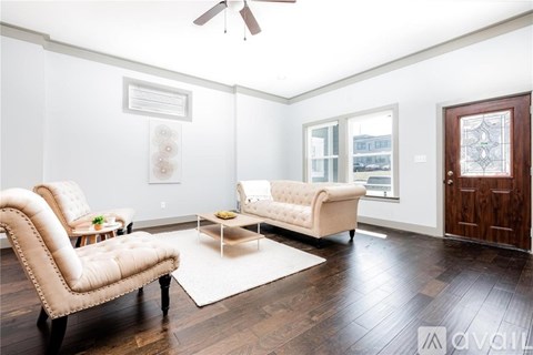 A living room with a white chair and a white couch.