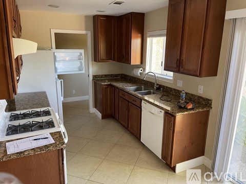 A kitchen with brown cabinets and a granite countertop.