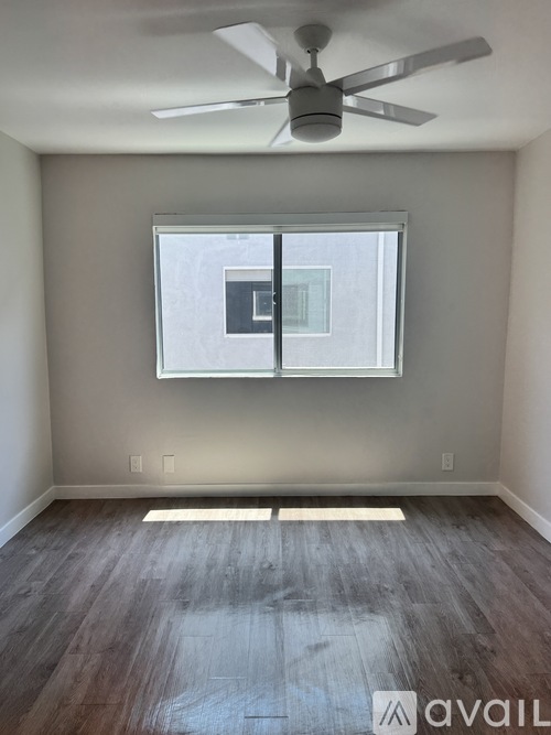 A room with a ceiling fan and a window.