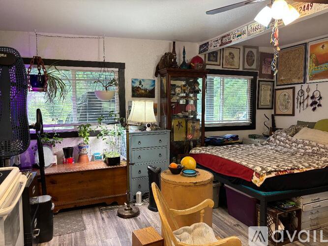 A room with a bed, a chair, a dresser, and a window.