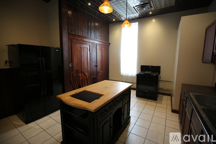 A kitchen with a wooden island and black appliances.