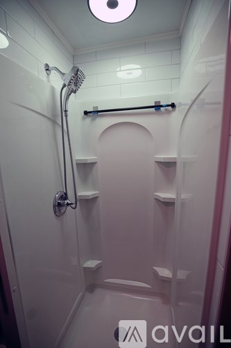 A white bathroom with a shower and shelves.