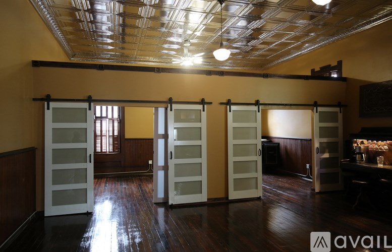 A room with a wooden floor and a ceiling with metal beams.