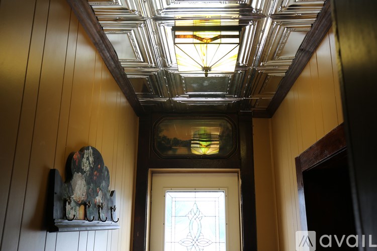 A stained glass window in a room with wooden walls.