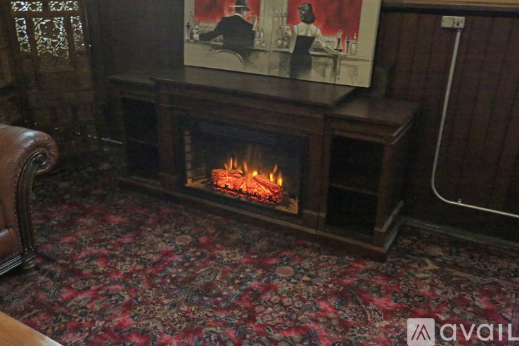 A fireplace with a painting above it and a carpet on the floor.