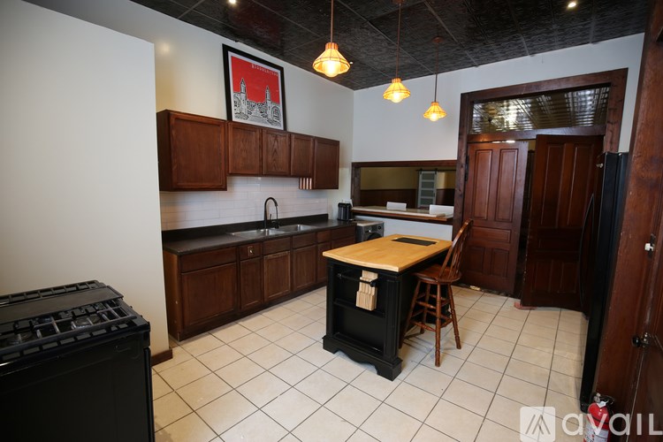 A kitchen with a black stove top oven and wooden cabinets.
