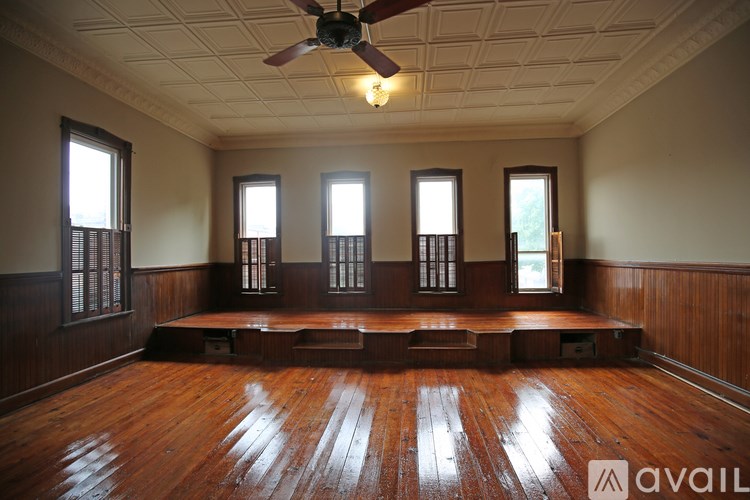 A room with wooden floors and a ceiling fan.