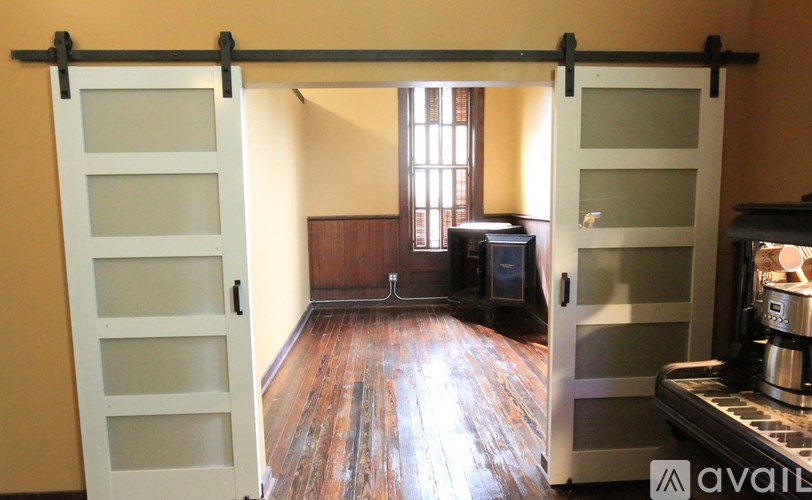 A room with a sliding door and wooden floors.