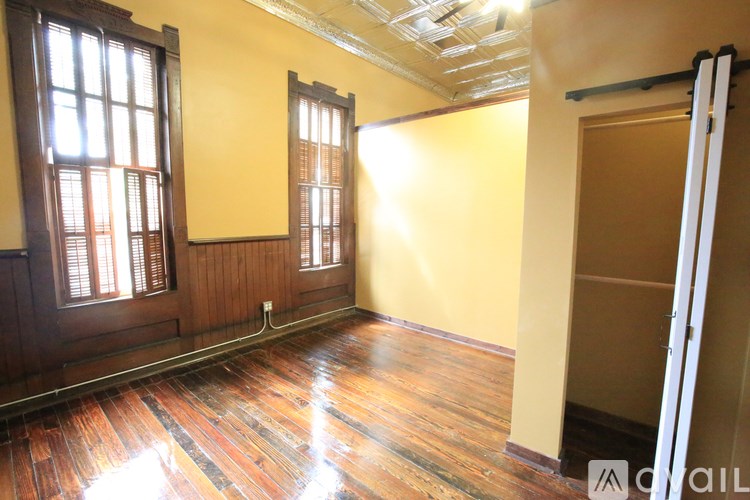 A room with wooden floors and a wall with a window.