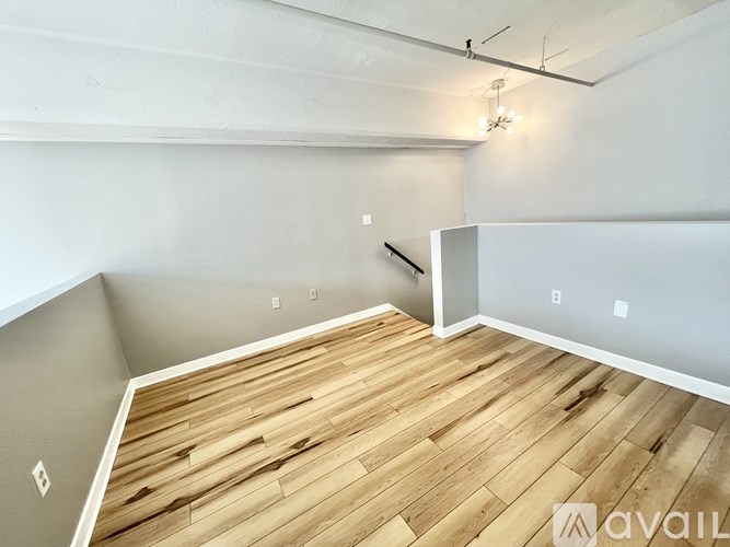 A room with wooden flooring and a white wall.