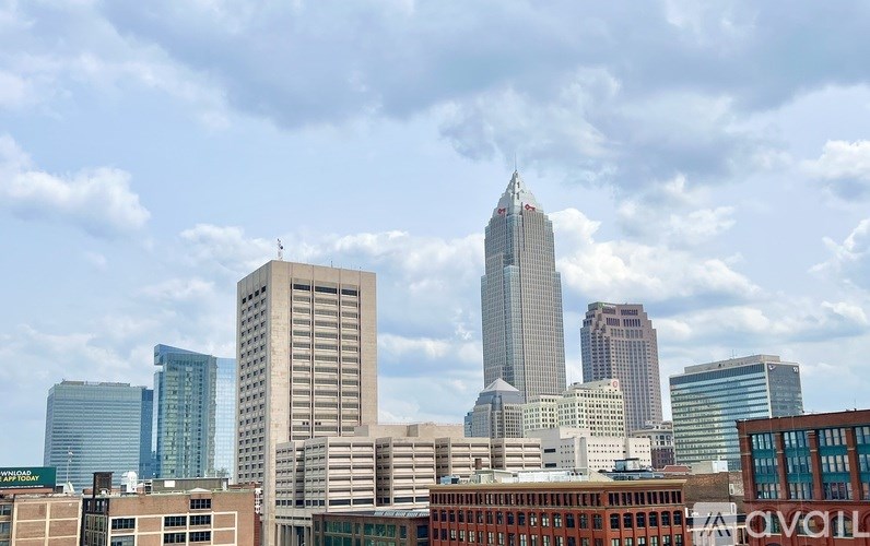 A city skyline with tall buildings under a cloudy sky.