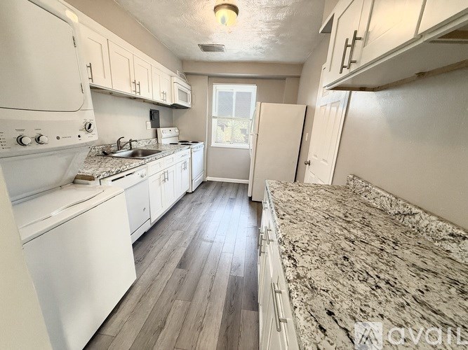 A kitchen with white appliances and cabinets.