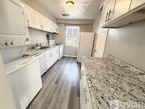 A kitchen with white appliances and cabinets.
