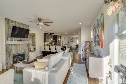 A living room with a white couch and a fireplace.