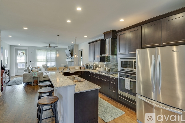 A modern kitchen with dark wood cabinets and stainless steel appliances.
