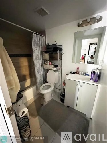 A bathroom with a toilet, sink, and mirror.