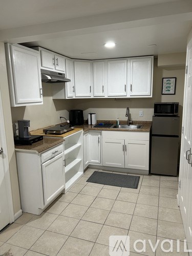 A kitchen with white cabinets and appliances.