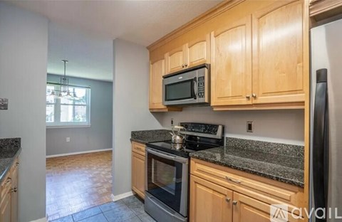 A kitchen with wooden cabinets and granite countertops.